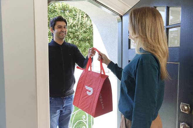 지난해 4월 미국 캘리포니아 샌프란시스코에서 도어대시 이용자가 배달을 받는 모습. (사진=AFP)