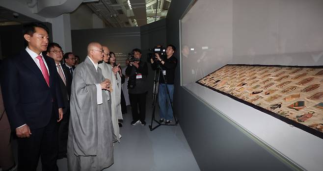 2일 서울공예박물관에서 개막한 특별전 '염원을 담아-실로 새겨 부처에 이르다' 전시장에서 오세훈 서울시장과 조계종 총무원장 진우스님, 최응천 국가유산청장, 태고종 총무원장 상진스님 등 참석자들이 보물 '자수가사'를 감상하고 있다. /뉴시스