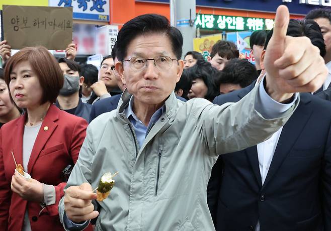 김문수 국민의힘 대선 후보가 6일 경북 포항시 죽도시장을 방문해 음식을 맛본 뒤 엄지손가락을 들어올리고 있다. 국민의힘 지도부가 한덕수 전 국무총리와의 단일화 협상 압박에 나선 가운데 김 후보는 ‘양보하지 마세요’라고 적힌 손팻말을 든 지지자를 향해 고개를 끄덕였다. 포항=뉴시스