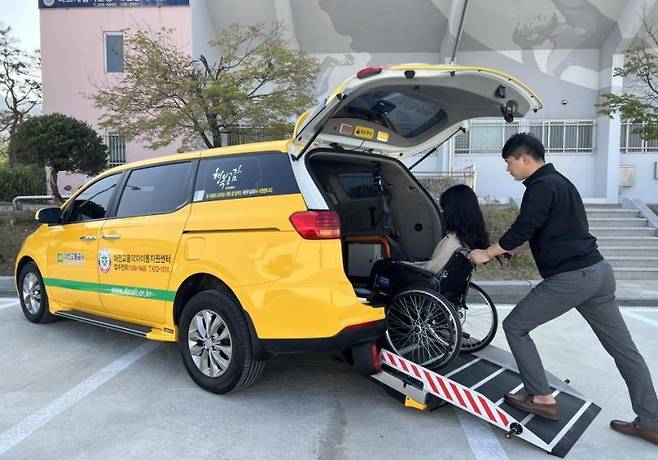 휠체어를 탄 장애인이 콜택시에 오르고 있다. 뉴스1