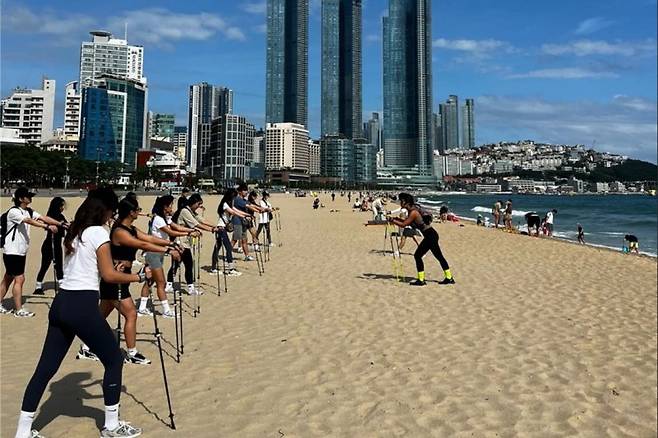 지난해 상반기 부산 해운대해수욕장에서 진행된 '해양치유 체험 프로그램' 모습. 해변 노르딕 워킹에 대한 강좌가 진행되고 있다. 부산관광공사 제공