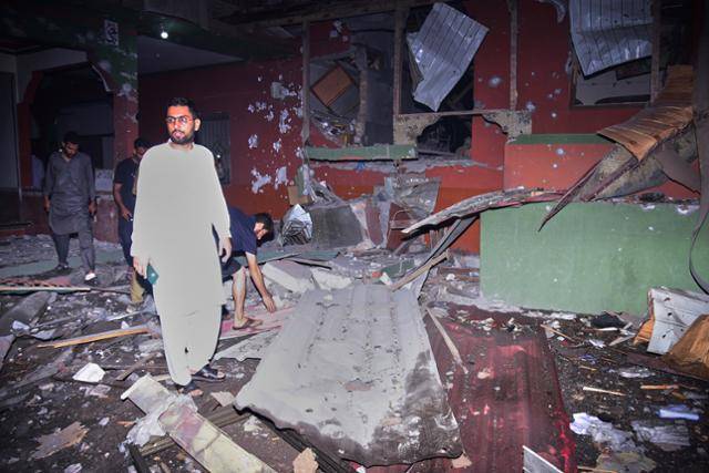 인도가 미사일 공격을 가한 7일, 파키스탄령 잠무카슈미르의 주도 무자파라바드의 한 건물에서 주민들이 공격으로 인한 피해 현황을 살펴보고 있다. 무자파라바드=AP 연합뉴스