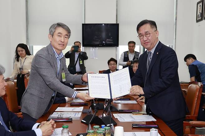 백호 서울교통공사 사장(왼쪽)이 공동건의문을 맹성규 국회 국토교통위원장에게 전달하는 모습/사진=서울교통공사