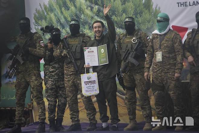 [누세이라트=AP/뉴시스]지난 2월 22일 가자지구 누세이라트에서 이스라엘 인질 오메르 솀이 석방 전 군중을 향해 손을 흔들고 있다. 트럼프 미국 대통령은 5월 6일 생존 인질이 3명 더 죽어 남은 건 21명 뿐이라고 밝혔다. 2025.05. 07.