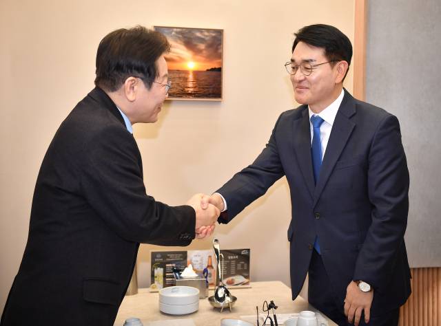 박용진(오른쪽) 전 더불어민주당 의원이 지난 2월 이재명 민주당 대선 후보와 만나 악수하는 모습. 뉴스1