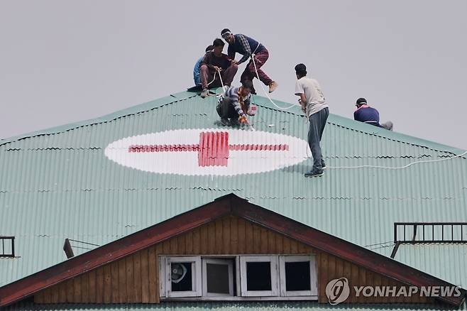 이곳은 병원입니다 인도령 카슈미르 지역의 한 건물 지붕에 병원을 표시하는 적십자 마크를 그리고 있는 시민들 [AP=연합뉴스 자료사진. 재판매 및 DB 금지]