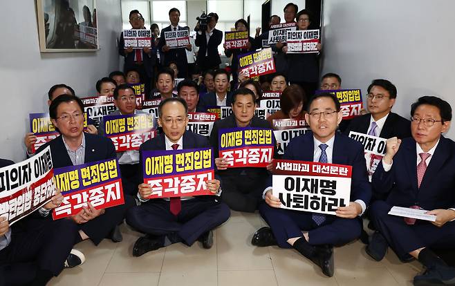 국민의힘 주호영 국회부의장을 비롯한 의원들이 7일 오후 서울 여의도 국회 행정안전위원회 회의실 앞에서 형사소송법 개정안과 공직선거법 개정안 강행 처리를 시도하는 더불어민주당을 규탄하는 손피켓을 들고 구호를 외치고 있다./뉴스1