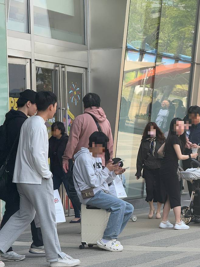 7일 낮 12시쯤 서울 송파구 신천동 롯데월드몰 1층 앞에 메타몽 카드를 구매하는 거래상이 앉아 있다. /이호준 기자