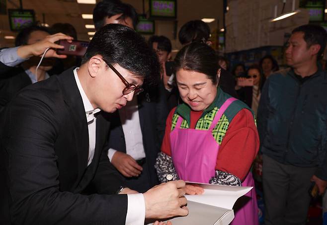제21대 대통령 선거 출마를 선언한 국민의힘 한동훈 전 대표가 2025년 4월10일 서울 동작구 노량진 수산시장에서 자신의 저서에 사인하고 있다. 연합뉴스