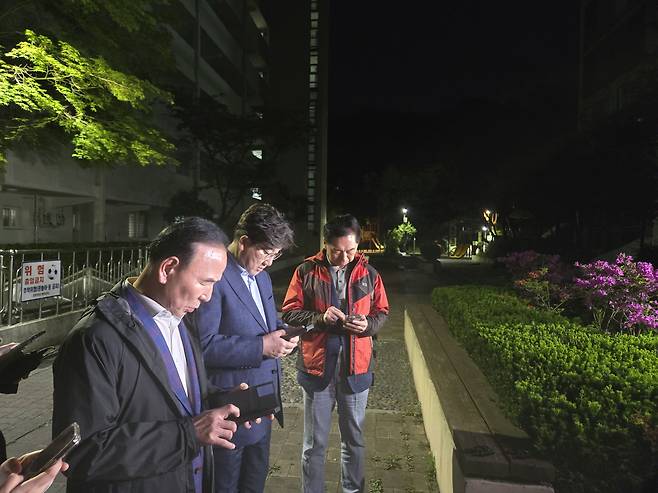 People Power Party (PPP) floor leader Kweon Seong-dong, center, along with lawmakers Kim Gi-hyeon, right, and Park Duk-hyum, read a statement from PPP presidential candidate Kim Moon-soo while waiting outside Kim’s residence in Bongcheon-dong, Gwanak District, southern Seoul, on the night of May 6, in an effort to persuade him to unify the candidacy. [JOONGANG ILBO]