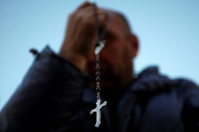 267대 교황을 선출하는 '콘클라베' 첫 투표에서 새 교황이 선출 불발됐다.사진은 지난7일(현지시각)  콘클라베 첫날 성 베드로 광장에 모인 한 사람이 묵주를 들고 있는 모습. /사진=로이터