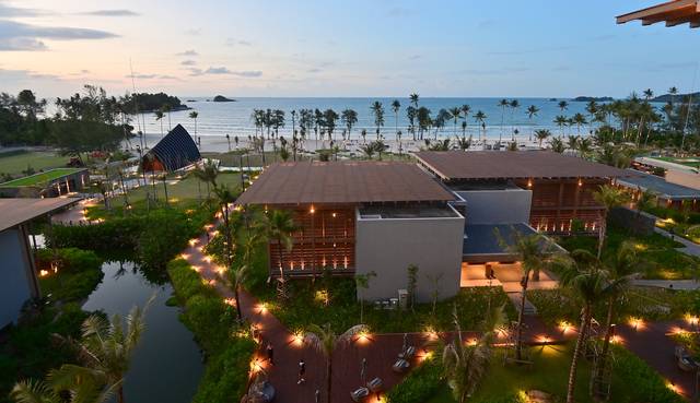 빈탄섬의 신상 리조트 ‘인디고 빈탄 라고이 비치’의 해 질 무렵 풍경. 야자수 늘어선 바다 경관과 불 켜진 리조트 정원의 조명이 낭만적이다. 고층 객실에서 내려다본 모습이다.