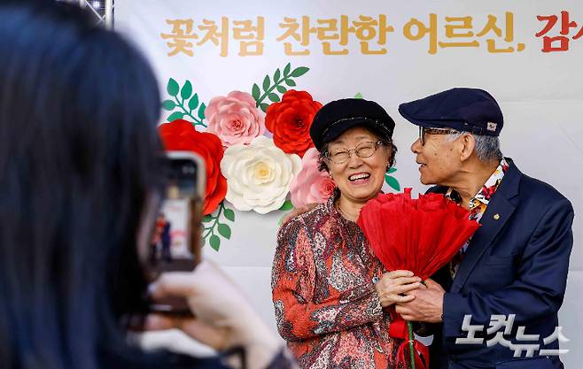 어버이날인 8일 서울 송파노인종합복지관에서 열린 '꽃처럼 찬란한 어르신, 감사해효(孝) 행사'에 참가한 어르신이 대형 카네이션을 들고 사진촬영 하고 있다. 박종민 기자