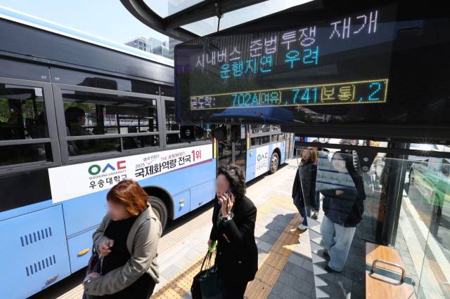 서울 시내버스 노조가 연휴가 끝난 뒤 첫차부터 준법투쟁(준법운행)을 재개한 7일 오전 서울 광화문의 한 버스정류장 전광판에 준법투쟁 재개로 인한 운행지연 안내문구가 표시되고 있다. 연합뉴스