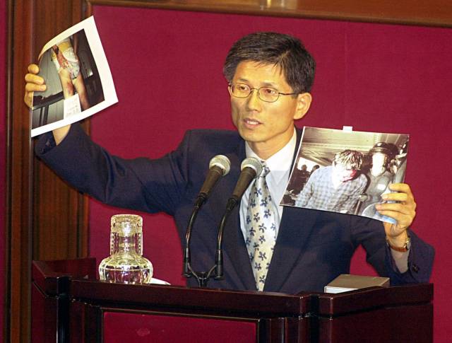 지난 2000년 7월 김문수 당시 한나라당 의원이 국회 본회의에서 호텔롯데 노조원들에 대한 경찰의 강경진압 의혹을 제기하며 사진을 들어보이고 있다, 연합뉴스