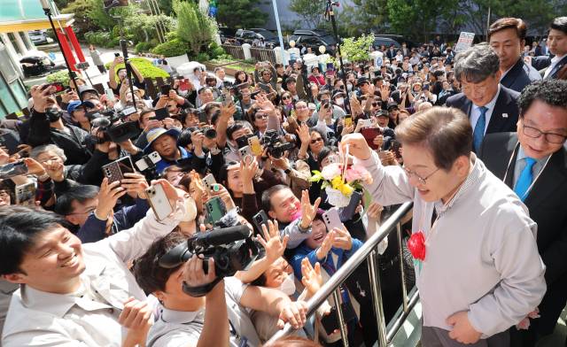 이재명 더불어민주당 대선 후보가 7일 전북 익산시 대한노인회 익산시지회에서 열린 노인회 간담회에 참석하던 중 어린이로부터 꽃다발을 받은 뒤 지지자들에게 들어보이고 있다. 연합뉴스