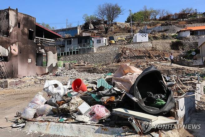 영덕 노물리에 쌓인 폐기물 (영덕=연합뉴스) 손대성 기자 = 지난 3월 대형산불 피해가 난 경북 영덕군 영덕읍 노물리에서 7일 중장비 작업자가 폐기물을 치우고 있다. 2025.5.7 sds123@yna.co.kr