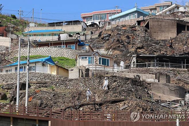 폐기물 정리 (영덕=연합뉴스) 손대성 기자 = 7일 경북 영덕군 영덕읍 석리 따개비 마을의 산불 피해 집에서 작업자들이 폐기물을 치우고 있다. 2025.5.7 sds123@yna.co.kr