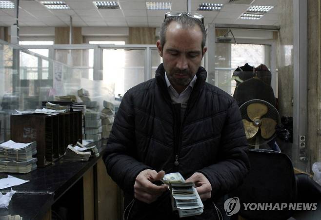 시리아 수도 다마스쿠스의 은행에서 직원이 지폐를 세고 있다.  [로이터 연합뉴스 자료사진. 재판매 및 DB 금지]