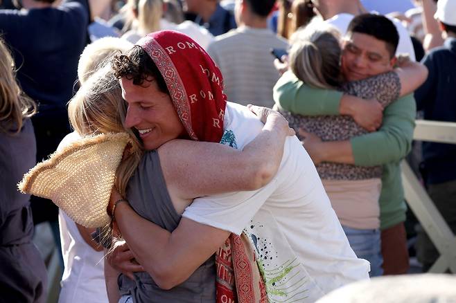 가톨릭 신자들이 성 베드로 대성전 앞에서 교황 선출 소식에 서로 축하하고 있다