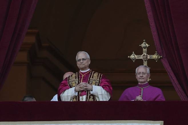 전세계 14억 가톨릭교도를 이끌 새 교황으로 선출된 레오 14세(가운데) 교황이 8일(현지시간) 바티칸 성 베드로 성당 발코니에 모습을 드러내고 있다. 레오 14세는 교황 선출 뒤 "모든 이들에게 평화를"이라고 축성했다. AP 연합
