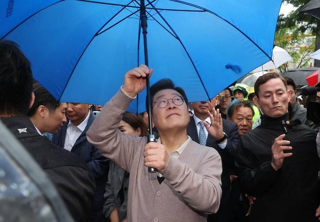 민심을 청취하는 '경청 투어'에 나선 이재명 더불어민주당 대선후보가 9일 경북 경주시 용강동 아파트단지 인근에서 비가 내리자 우산을 펼치고 있다. 사진=뉴시스
