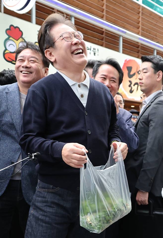 더불어민주당 이재명 대선 후보가 '골목골목 경청투어' : 단양8경편'에 나선 4일 강원도 영월군 영월서부시장에서 한 상인으로부터 엄나무 순을 구매한 뒤 함박웃음을 짓고 있다. 사진=연합뉴스