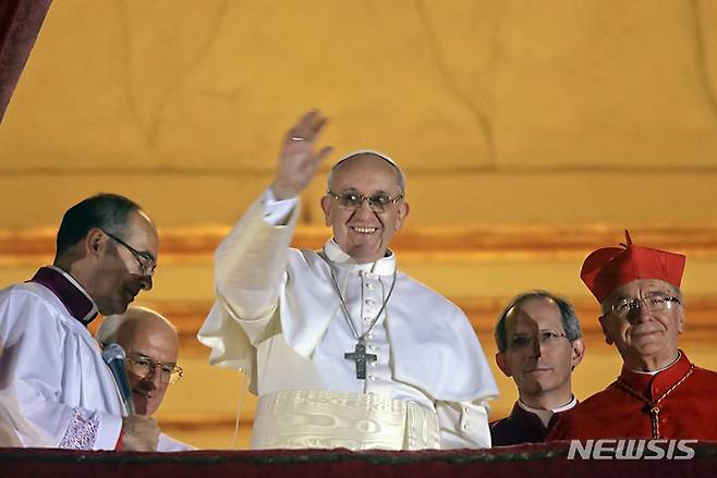 [바티칸=AP/뉴시스] 고(故) 프란치스코 교황이 2013년 3월 13일(현지 시간) 선출 직후 바티칸 성 베드로 대성당 난간에 나와 군중에게 손을 흔드는 모습. 프란치스코 교황은 화려한 금사 자수와 비단 소재 제의 대신 소박한 흰색 제의를 착용했었다. 2025.05.09. *재판매 및 DB 금지