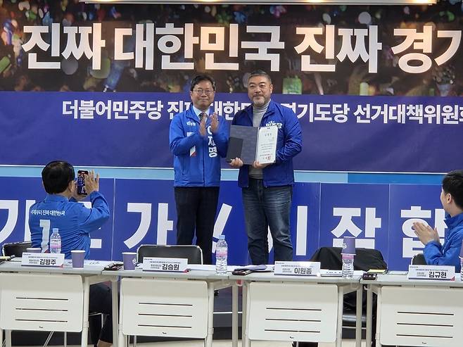 ▲ 김승원 총괄공동상임선대위원장이 10일 수원시 팔달구 민주당 경기도당 사무실에서 열린 선대위 첫 회의에서 이원종 공동상임선대위원장에게 경청노트를 전달하고 기념사진을 찍고 있다.