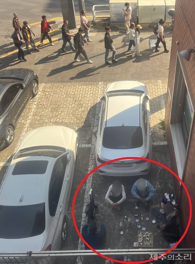 탐라문화광장 바로 옆 상가 주차장. 지나가는 관광객들을 아랑곳하지 않고 주취자들이 술을 마시며 바둑을 두고 있다. 사진=독자 제공 ⓒ제주의소리