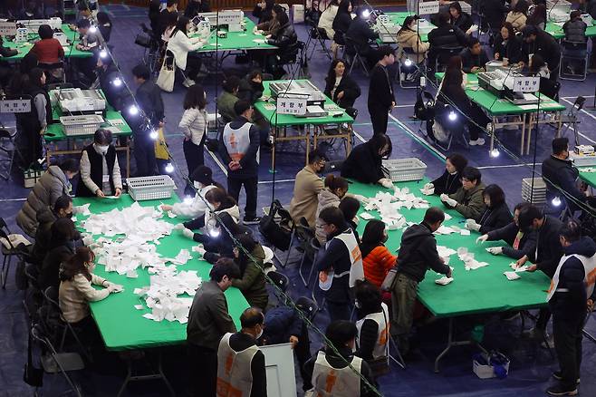 부산교육감 재선거가 치러진 지난 4월 2일 한 개표소에서 사무원과 참관인(흰 조끼 입은 이들)이 개표 업무를 하고 있다. 이처럼 선거 때마다 일시 인력이 대거 채용된다. /연합뉴스