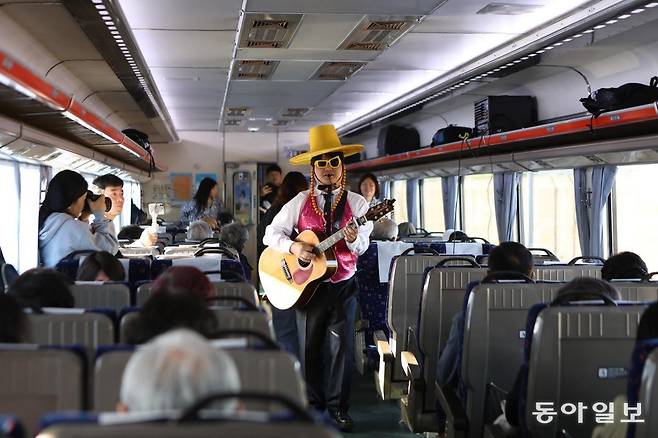 충남으로 떠나는 레트로 낭만열차에서 통기타 가수가 노래를 부르고 있다.