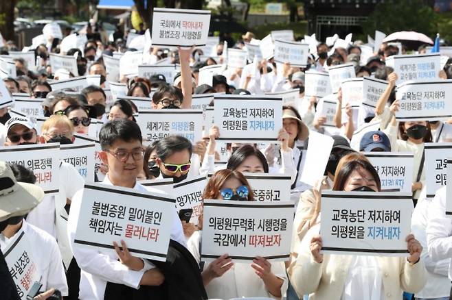 2024년 10월, 전국의과대학교수협의회 등 의료단체가 용산 대통령실 앞에서 '전국 의과대학 교수 결의대회'를 열고 의대 증원을 규탄하는 모습. 2024년 정부의 의대 정원 확대 발표에 맞서 의료단체 및 의대생은 사임, 집회, 휴학 등 집단 행동에 나섰다. 동아일보 제공