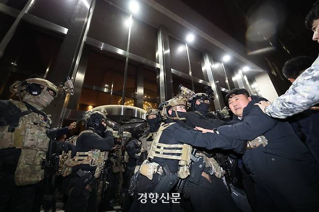 윤석열 대통령이 비상계엄을 선포한 12월 3일을 넘겨 다음날인 4일 새벽 계엄군이 서울 여의도 국회의사당 본청 앞에서 국회 사무처, 당직자들과 몸싸움을 하고 있다.  성동훈 기자