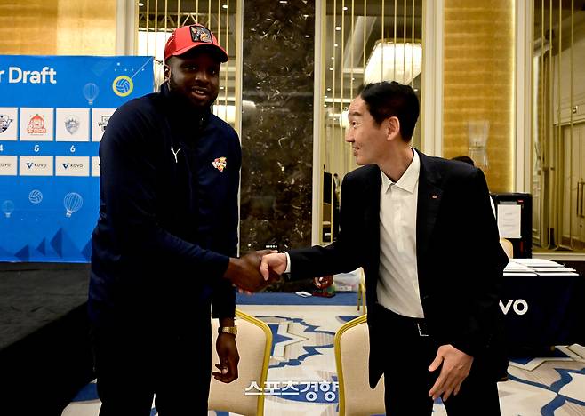 한국전력 김철수 단장(오른쪽)이 2025 KOVO 남자부 외국인 선수 드래프트 행사에서 1순위 유력 후보인 쉐론 베논 에반스(캐나다)를 뽑은 뒤 악수하고 있다. KOVO 제공
