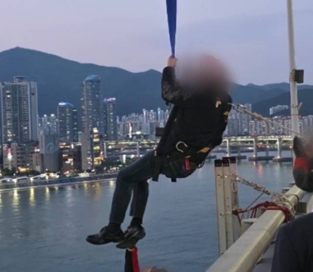 11일 광안대교 고공 농성에 나선 형제복지원 피해자 최승우 씨가 크레인으로 구조되고 있다. 해운대경찰서 제공