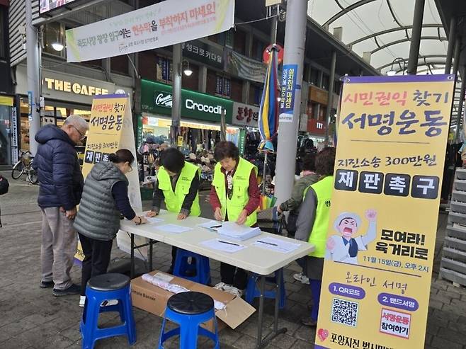 포항지진범시민대책본부가 포항 죽도시장에서 공정한 판결을 촉구하는 서명운동을 벌이고 있다. 포항지진범시민대책본부 제공
