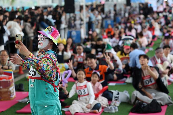 2025 한강 멍때리기 대회에 피에로 차림으로 온 참가자가 11일 서울 서초구 반포한강공원 잠수교에서 다른 참가자들과 함께 사진을 찍고 있다. 김영원 기자 forever@hani.co.kr