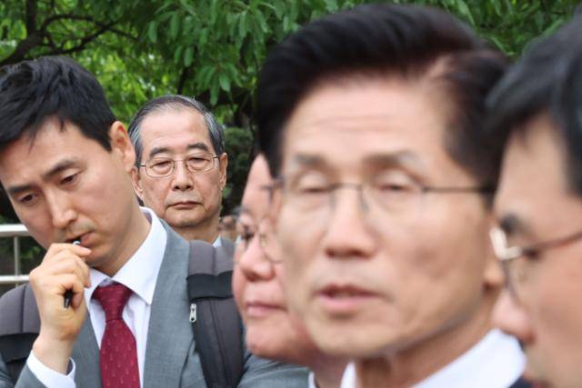 8일 서울 여의도 국회의사당에서 당시 무소속 대선 예비후보였던 한덕수(왼쪽 두 번째) 전 국무총리가 김문수(오른쪽 두 번째) 당시 국민의힘 대선 후보와 단일화 관련 회동을 마친 뒤 김 후보의 대언론 브리핑을 듣고 있다. 뉴시스