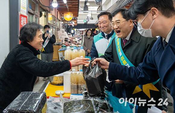 주낙영 경주시장이 전통시장 상인을 만나 물건을 구입하며 인사를 나누고 있다.  [사진=경주시청]