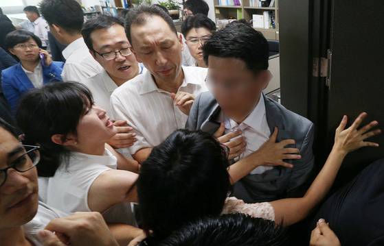 2013년 8월 서울 여의도 국회 의원회관 이석기 의원 사무실에서 국정원 직원들과 통합진보당 관계자들이 압수수색 영장 집행 직전 몸싸움을 벌이고 있다. 오른쪽에서 둘째 하얀 와이셔츠를 입은 사람이 하동환 전 국정원 대공수사단장이다. 당시에는 RO 담당 수사과장이었다. 당원들에게 옷깃을 잡히고 모자이크로 표기된 사람도 국정원 수사관이다. 뉴스1