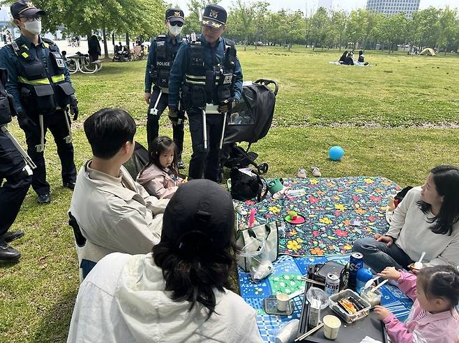 11일 여의도 한강공원에서 ‘K-스마트 순찰’ 시범운영의 일환으로 웨어러블 로봇을 착용한 경찰이 나들이 중인 시민들의 안전 상태를 확인하고 있다. [김송현 기자]