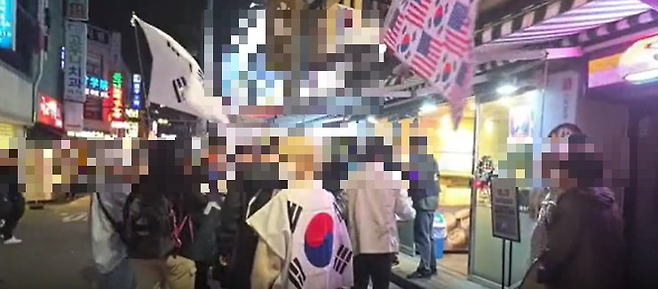 지난달 17일 윤 전 대통령 지지자들이 모인 ‘자유대학’ 시위대들이 서울 광진구 건대입구 인근 ‘양꼬치 골목’에서 행진을 하다 인근 가게 종업원과 충돌을 빚었다. [유튜브 진정한 애국자 TV 캡처]