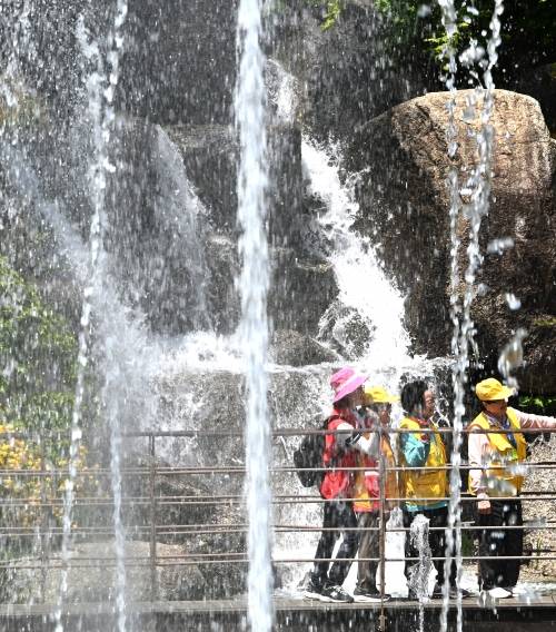 초여름 날씨를 보인 지난 8일 경기 안산시 노적봉 인공폭포 공원을 찾은 시민들이 시원하게 쏟아지는 폭포수를 바라보며 산책하고 있다. 뉴시스
