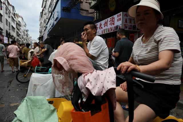 10일 중국 광둥성 광저우 다탕지구의 한 거리에서 섬유 공장 채용 담당자들이 일자리를 찾는 사람들을 기다리고 있다. 로이터연합뉴스