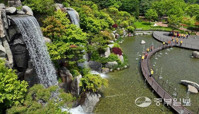 초여름 날씨를 보인 12일 오후 안산시 노적봉폭포공원을 찾은 시민들이 시원하게 쏟아지는 폭포수를 바라보고 있다. 김경민기자