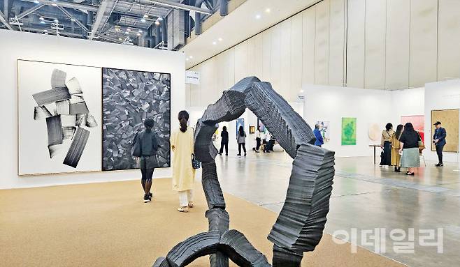 부산 해운대구 벡스코에서 열린 ‘아트부산 2025’ 전경. 지난 8일 VIP 프리뷰를 시작으로 11일까지 나흘간 일정을 마치고 폐막했다. 전반적으로 한산한 분위기 속에서도 조현화랑이 내건 이배 작가의 작품 앞으로는 관람객들이 쉼 없이 찾아들었다. 대형회화 ‘붓질 A35’(2024, 260×170㎝ 왼쪽)와 ‘불로부터-R’(2003), 청동조각 ‘붓질 S-1’(2022, 193×143×183㎝ 앞쪽) 등 출품작 3점은 첫날 모두 팔렸다(사진=오현주 문화전문기자).
