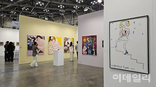 ‘아트부산 2025’ 야리라거갤러리 전경. 영국작가 로즈 와일리가 자화상으로 제작한 판화작품 ‘다른 유형’(2019)이 오른쪽에 걸렸다. 이 작품은 1500만원에 팔렸다. 안쪽 노란 벽에 영국 신진작가 갈리나 먼로의 작품들이 보인다(사진=오현주 문화전문기자).