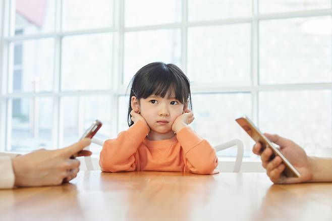 자녀 곁에서 부모가 스마트폰이나 태블릿을 자주 사용하면 아이의 뇌 발달과 정서 건강에 부정적인 영향을 줄 수 있다는 연구 결과가 나왔다. [사진=게티이미지뱅크]