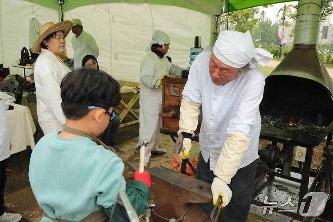 ‘울산쇠부리축제’가 11일 울산 북구 달천철장에서 열렸다. 사진은 쇳덩이를 망치로 두들겨 호미를 만드는 모습.2025.5.11./뉴스1 김세은 기자